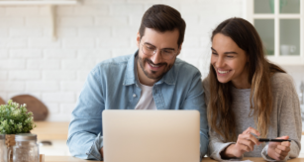 Couple smile looking at a laptop