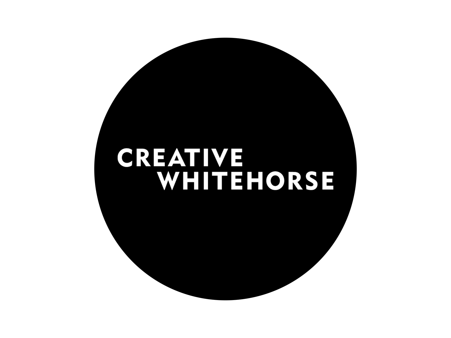 Black circle with Creative Whitehorse written in white text in the centre 