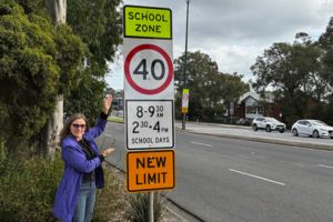 a person standing and pointing at a road sign