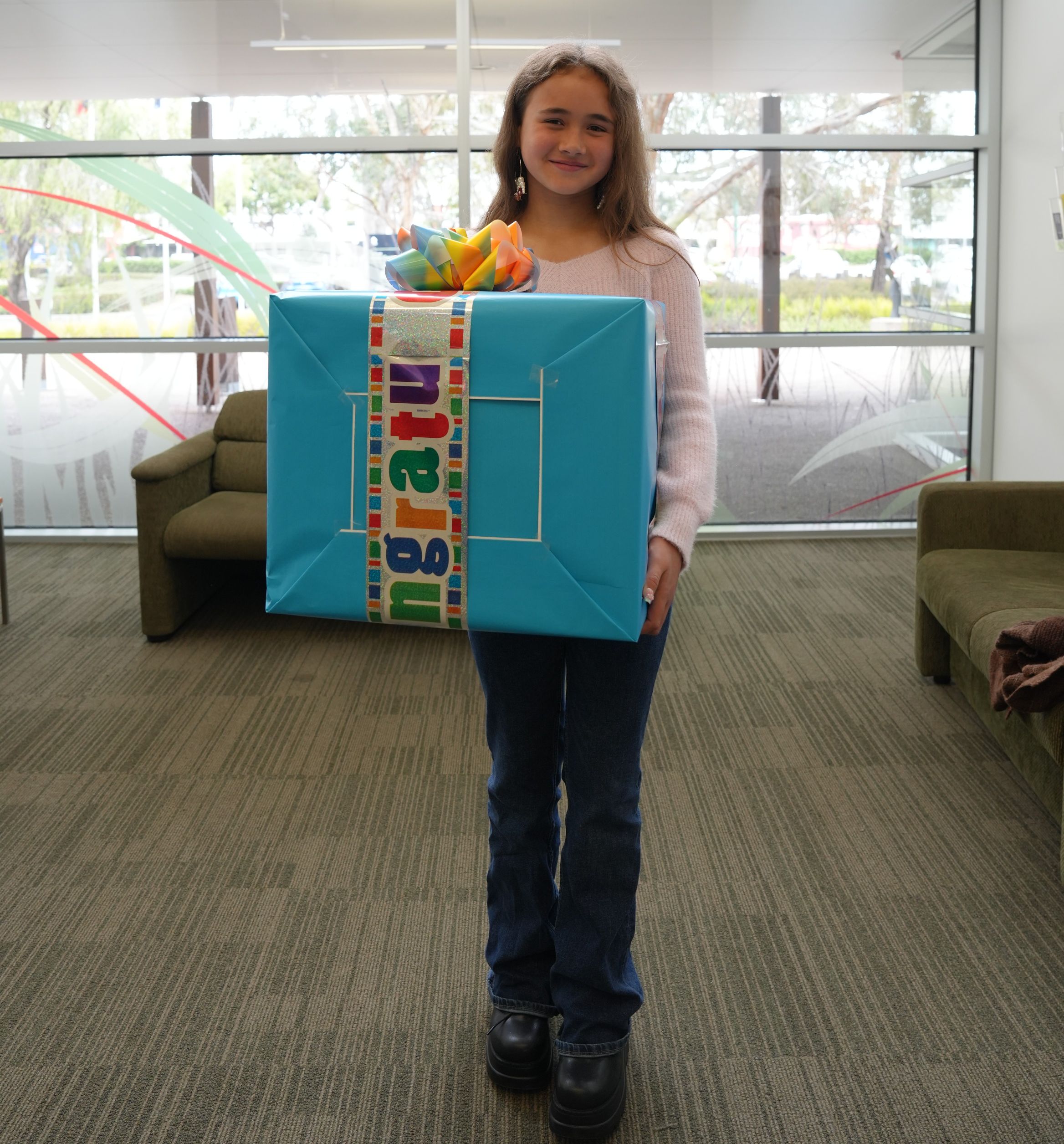 a young person holding a large gift box