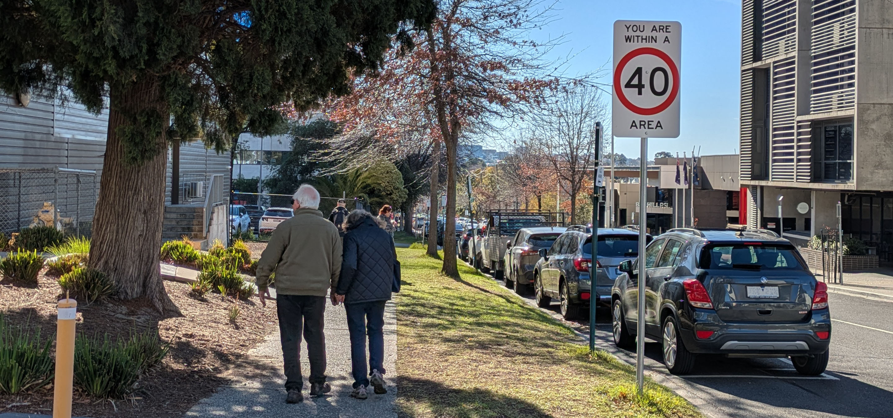 Two older people walking in Box Hill near 40km sign