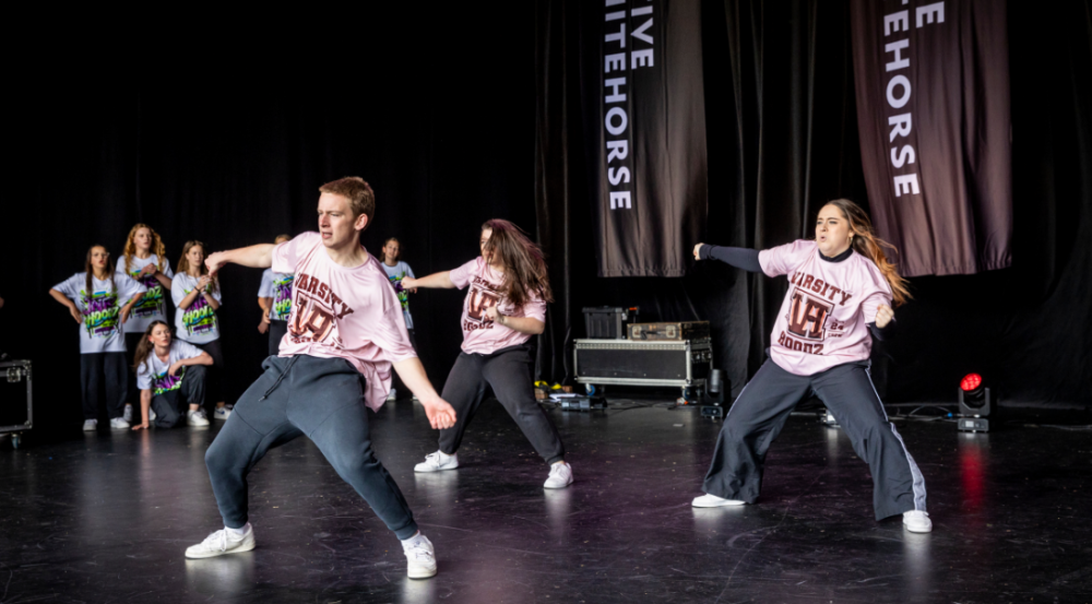 group of young people dancing in a street dance style on a stage