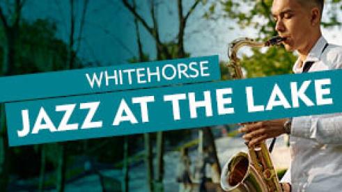 man in white shirt playing saxophone in a garden 