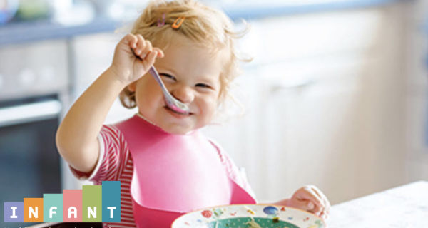 Toddler eating food with a spoon