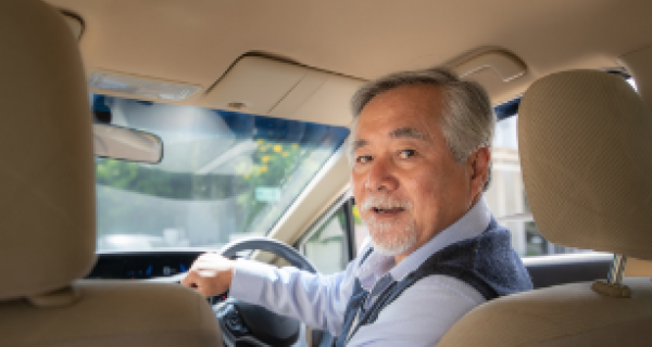 an elderly Asian man in driver's seat