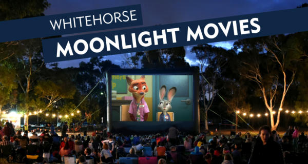 Movie up on screen, with a crowd and lights 