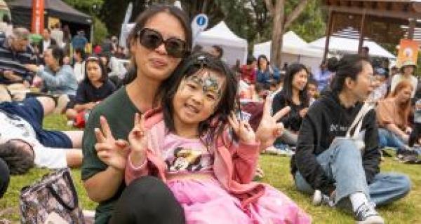 an adult and a child at an outdoor festival