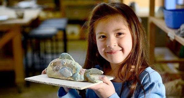 Child with a clay creation 