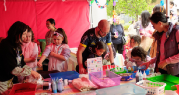 group of adults and children creating tie die bags at tables