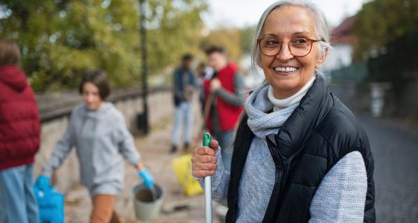 Mature women volunteer cleaning street with team - Medium.jpg