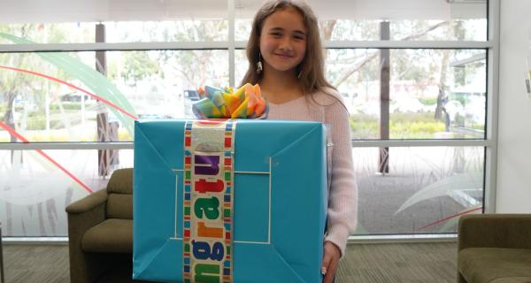 a young person holding a large gift box