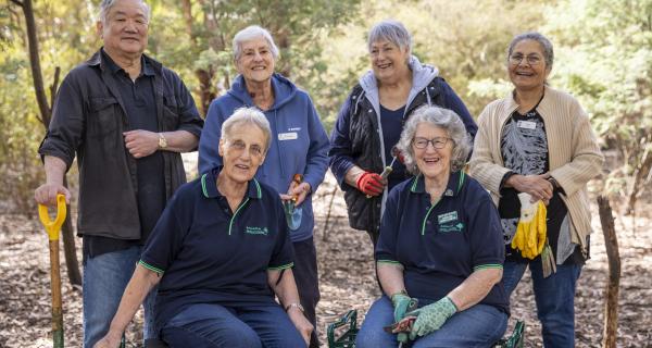 Six environmental volunteers standing and sitting smiling.