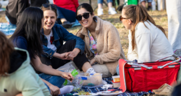 Women sitting on a picnic blanket laughing