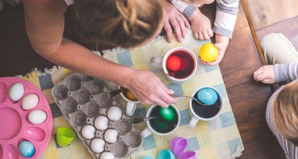 Children dipping eggs in dye 