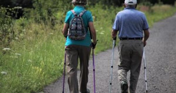 two people walk through park