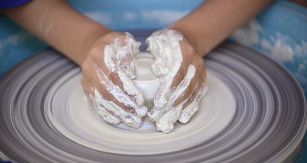 Hands sculpting on a ceramic wheel 
