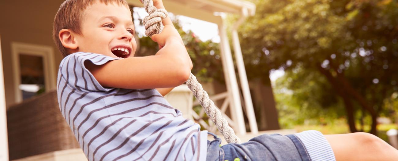 Young boy enjoying himself on a rope swing