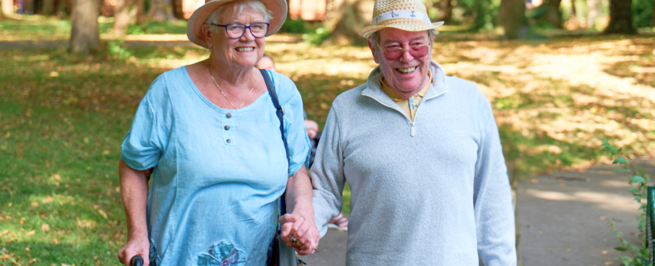 Lady and man walking with frame holding hands 