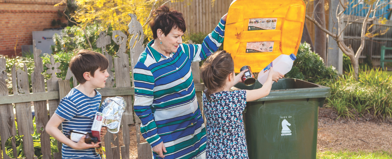 People placing items in recycling bin